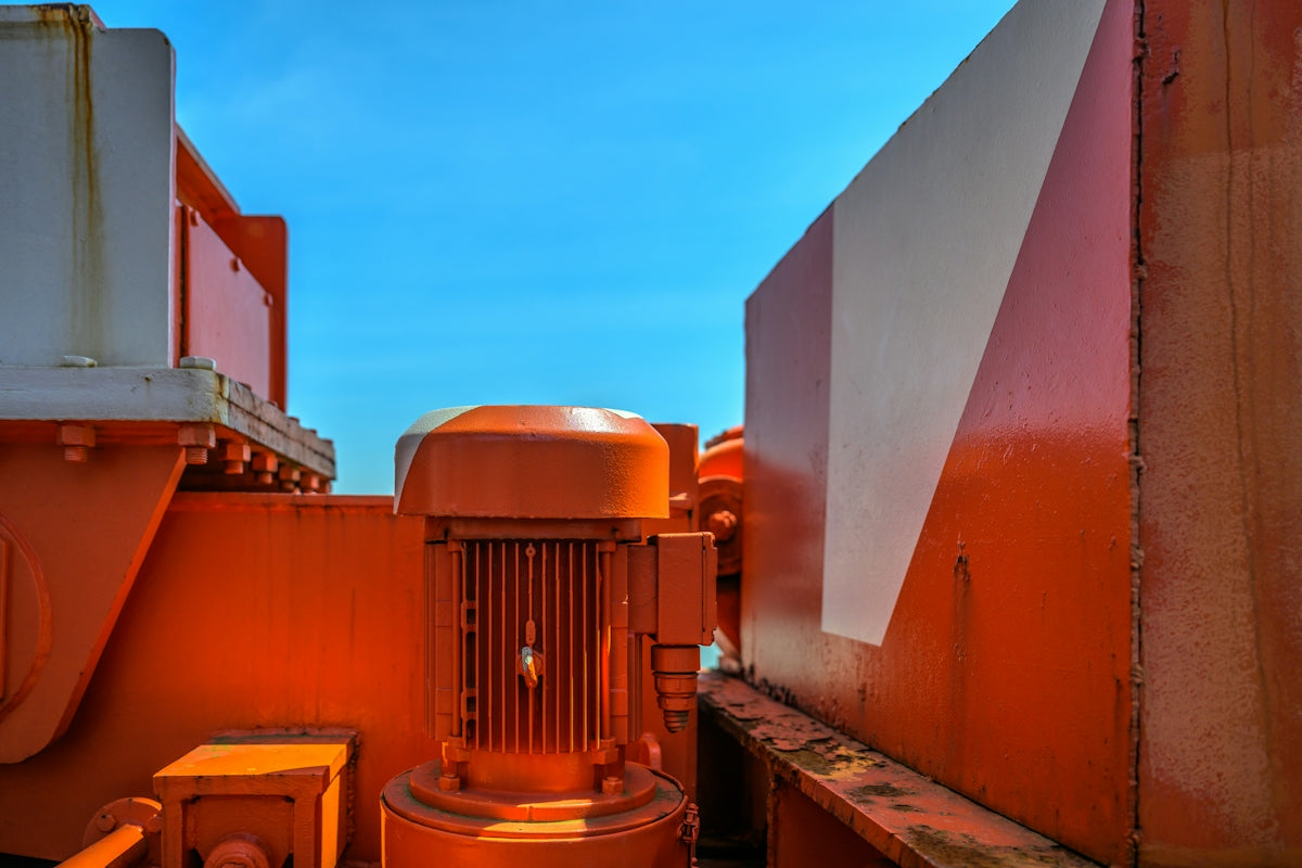 a large orange machine sitting next to a building
