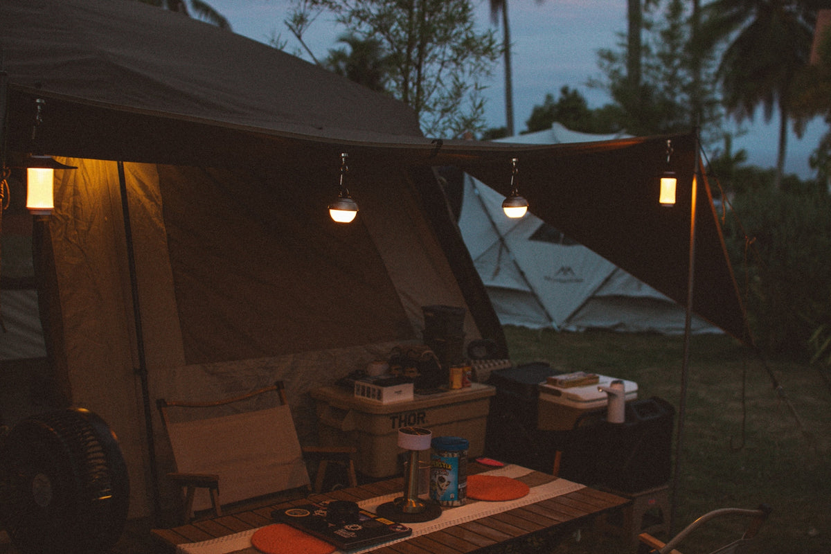 Camping at dusk with lit lanterns