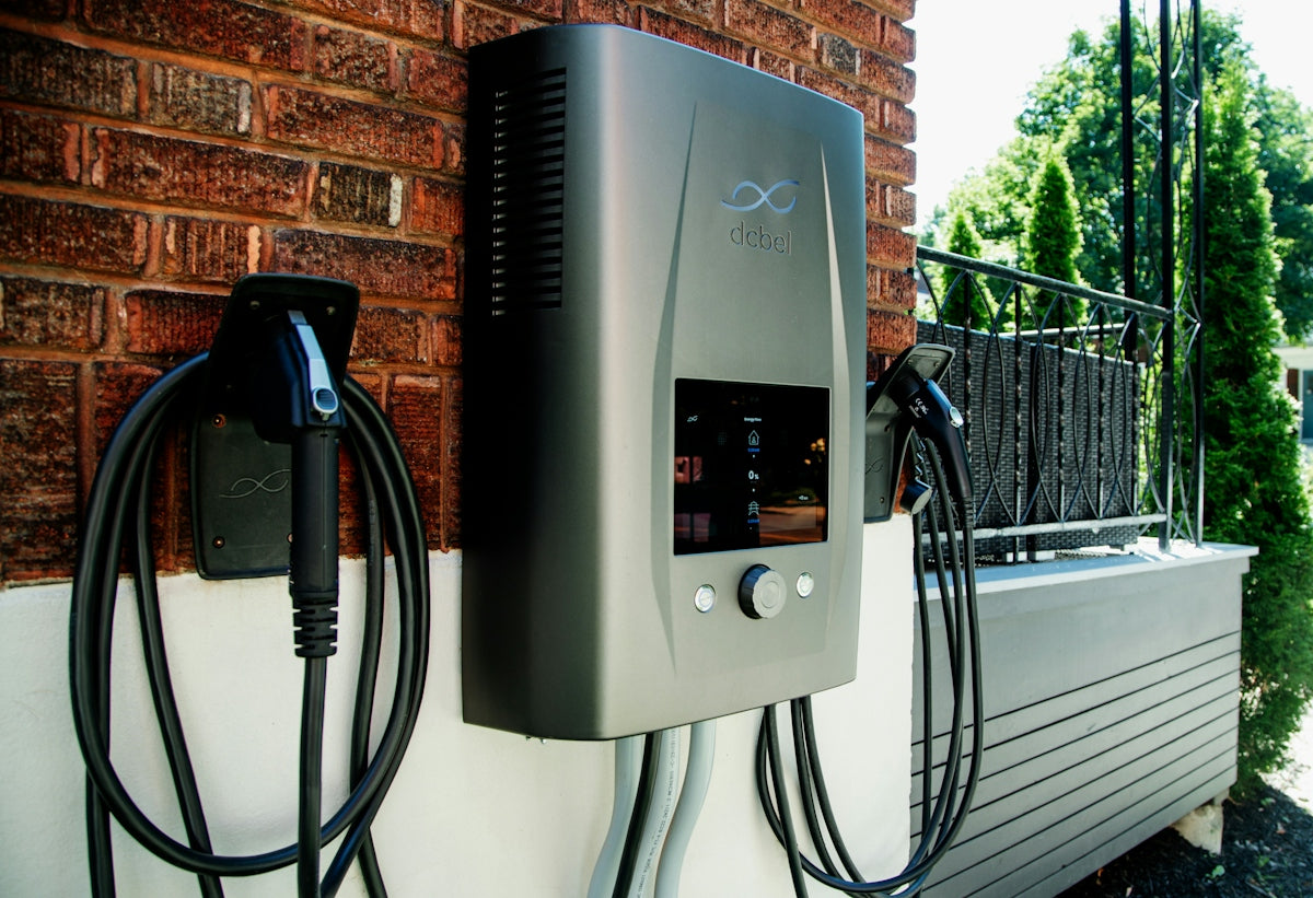 Electric car charging station mounted on brick wall