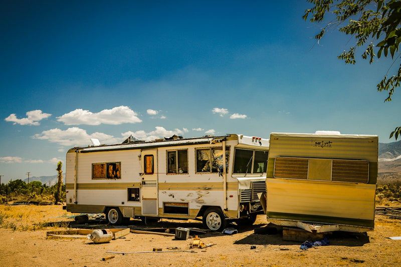 Old rv and trailer parked in a dry, outdoor setting